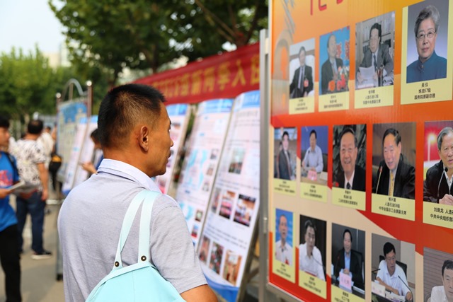 家长驻足观看学院杰出员工展  全运摄影